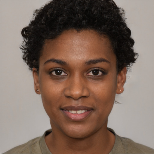 Joyful black young-adult female with short  black hair and brown eyes