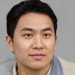 Joyful asian young-adult male with short  brown hair and brown eyes