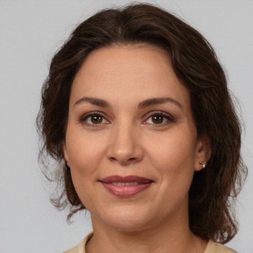 Joyful white adult female with medium  brown hair and brown eyes