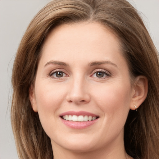 Joyful white young-adult female with long  brown hair and grey eyes