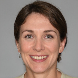 Joyful white adult female with medium  brown hair and grey eyes