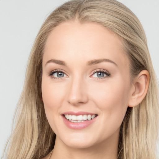 Joyful white young-adult female with long  brown hair and blue eyes