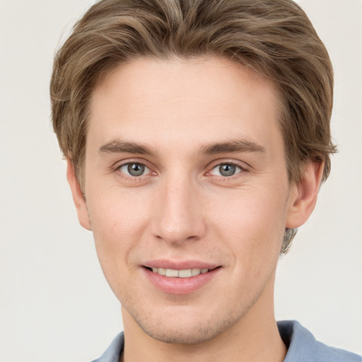 Joyful white young-adult male with short  brown hair and grey eyes