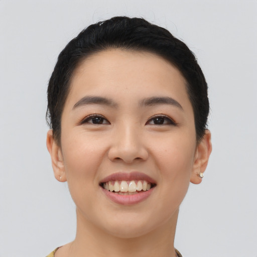 Joyful asian young-adult female with short  black hair and brown eyes