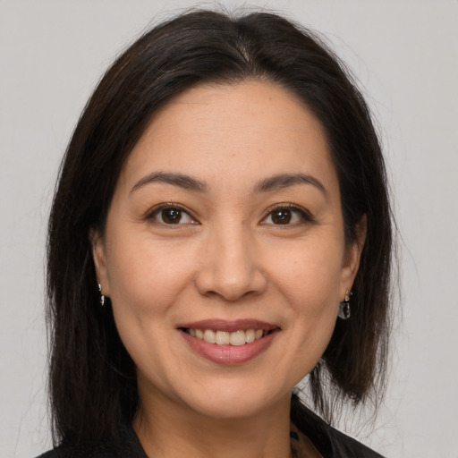 Joyful latino young-adult female with medium  brown hair and brown eyes