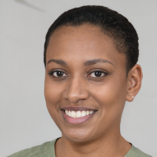 Joyful black young-adult female with short  brown hair and brown eyes