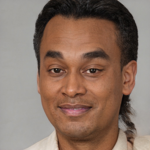 Joyful latino adult male with short  black hair and brown eyes