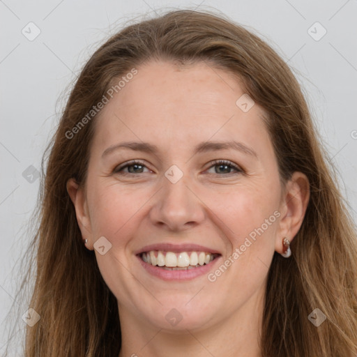 Joyful white adult female with long  brown hair and grey eyes