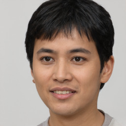 Joyful asian young-adult male with short  black hair and brown eyes