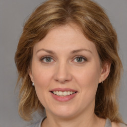 Joyful white adult female with medium  brown hair and grey eyes