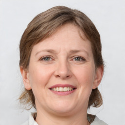 Joyful white adult female with medium  brown hair and grey eyes