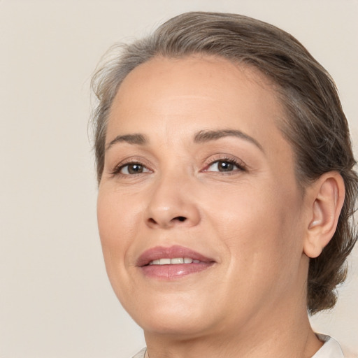 Joyful white adult female with medium  brown hair and brown eyes