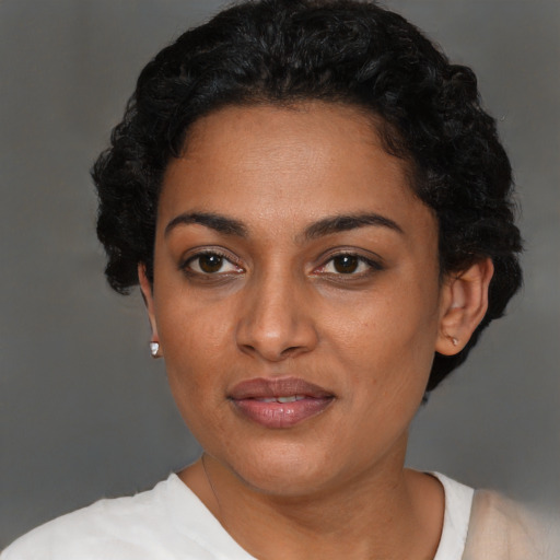 Joyful black young-adult female with short  black hair and brown eyes