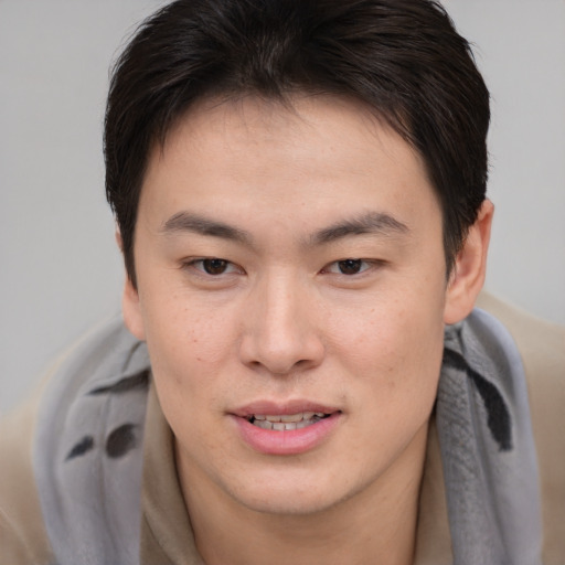 Joyful asian young-adult male with short  brown hair and brown eyes