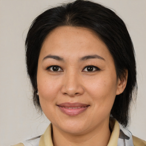 Joyful latino adult female with medium  brown hair and brown eyes
