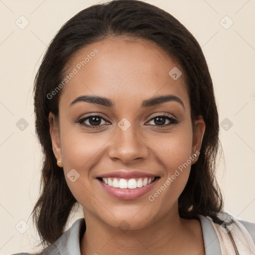 Joyful latino young-adult female with long  brown hair and brown eyes