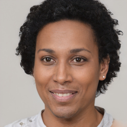 Joyful black adult female with short  brown hair and brown eyes