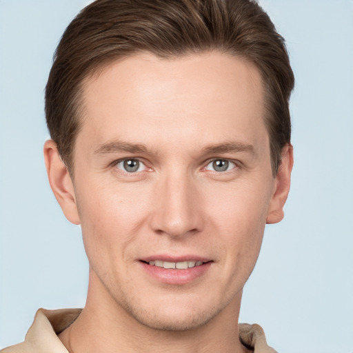 Joyful white young-adult male with short  brown hair and grey eyes