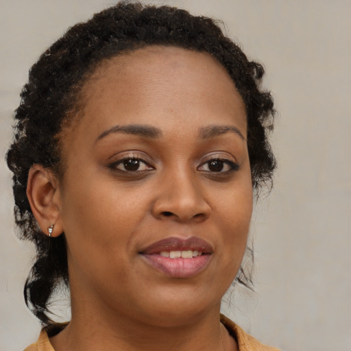 Joyful black young-adult female with medium  brown hair and brown eyes