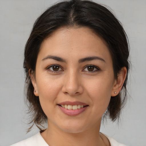 Joyful latino young-adult female with medium  brown hair and brown eyes