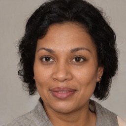 Joyful black adult female with medium  brown hair and brown eyes