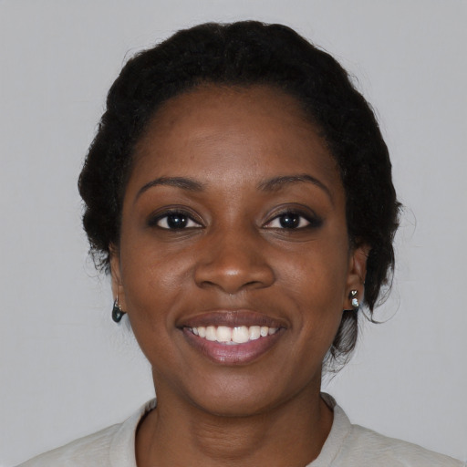 Joyful black young-adult female with medium  black hair and brown eyes