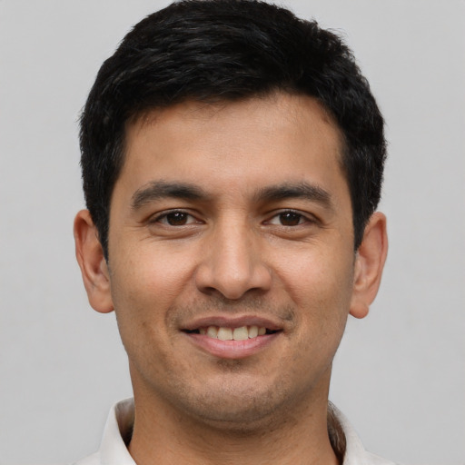 Joyful latino young-adult male with short  black hair and brown eyes