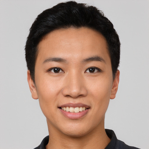 Joyful asian young-adult male with short  black hair and brown eyes