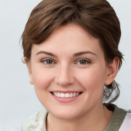 Joyful white young-adult female with medium  brown hair and blue eyes