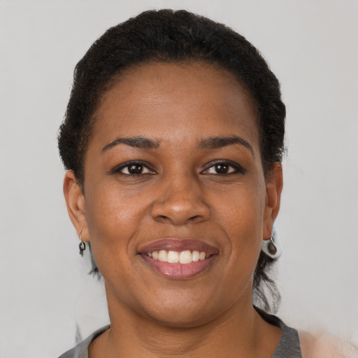 Joyful black adult female with short  brown hair and brown eyes