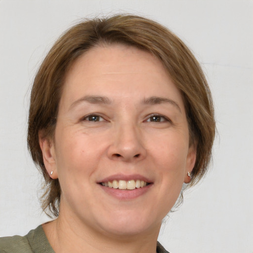 Joyful white adult female with medium  brown hair and grey eyes