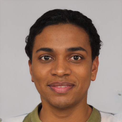Joyful black young-adult male with short  black hair and brown eyes
