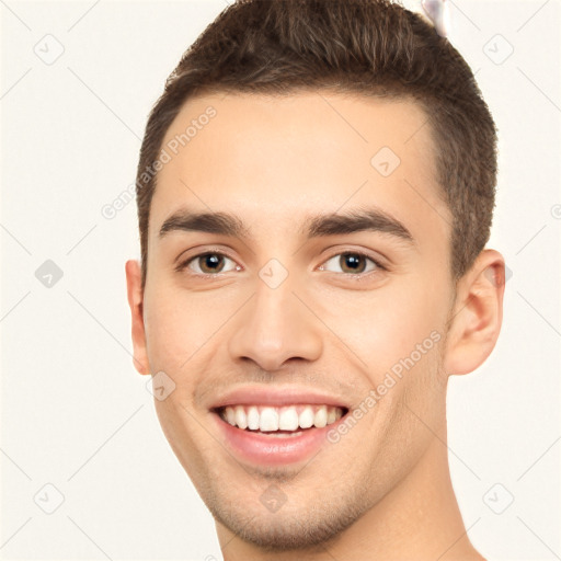 Joyful white young-adult male with short  brown hair and brown eyes