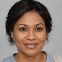 Joyful black adult female with medium  brown hair and brown eyes