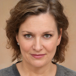 Joyful white adult female with medium  brown hair and grey eyes