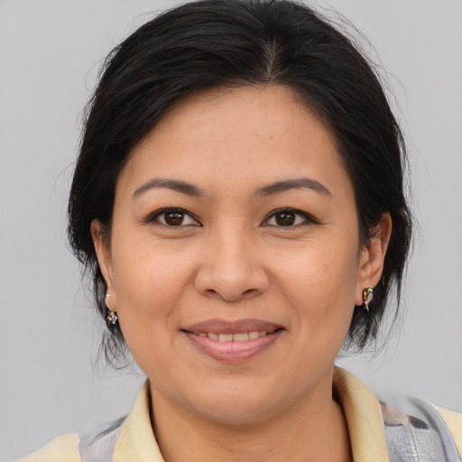 Joyful asian adult female with medium  brown hair and brown eyes