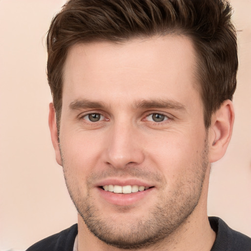 Joyful white young-adult male with short  brown hair and grey eyes