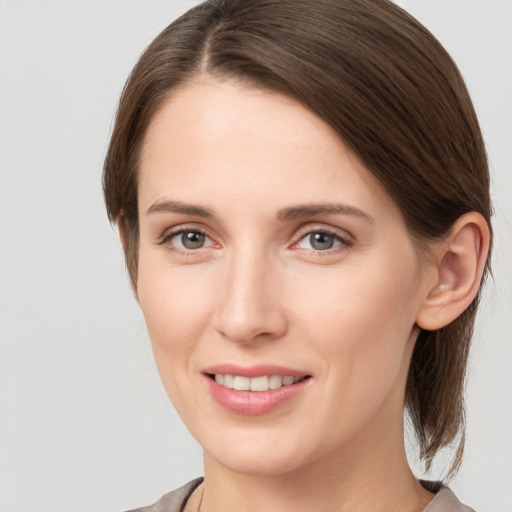 Joyful white young-adult female with medium  brown hair and grey eyes