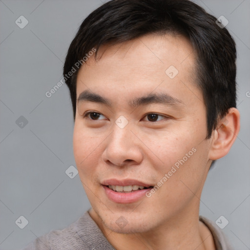 Joyful asian young-adult male with short  brown hair and brown eyes