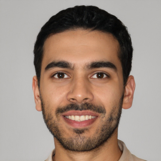 Joyful latino young-adult male with short  black hair and brown eyes