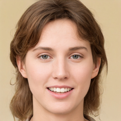 Joyful white young-adult female with medium  brown hair and green eyes