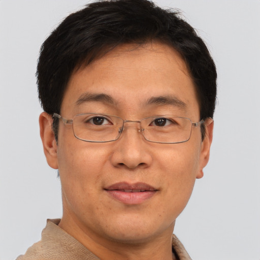 Joyful asian adult male with short  brown hair and brown eyes