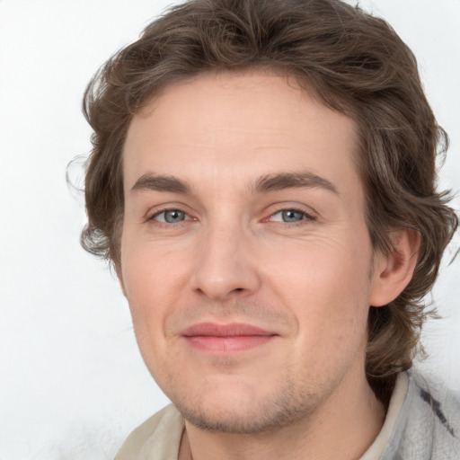 Joyful white young-adult male with medium  brown hair and grey eyes