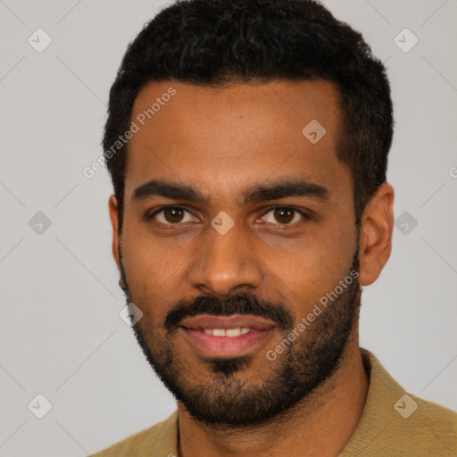 Joyful black young-adult male with short  black hair and brown eyes