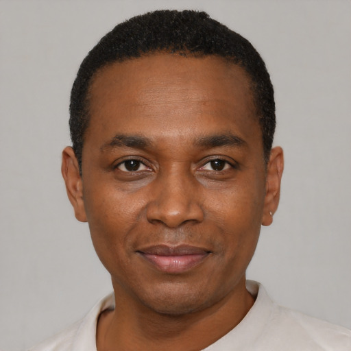 Joyful black young-adult male with short  black hair and brown eyes