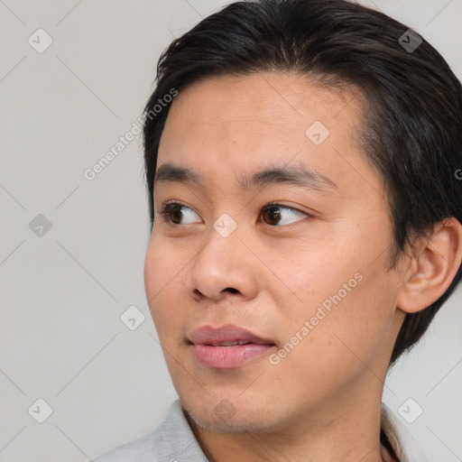 Joyful asian young-adult male with short  brown hair and brown eyes