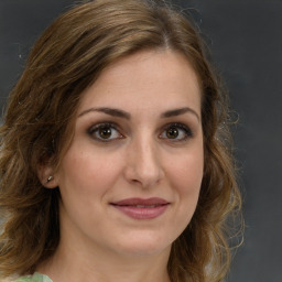 Joyful white young-adult female with medium  brown hair and green eyes