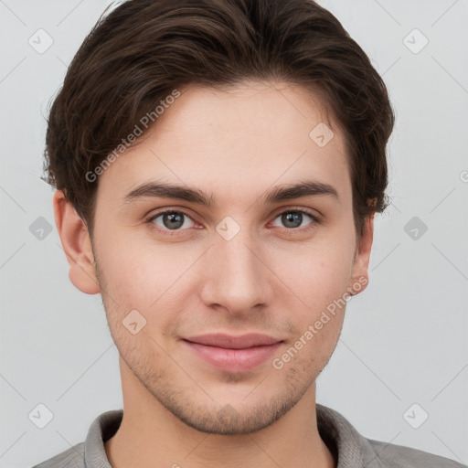 Joyful white young-adult male with short  brown hair and grey eyes