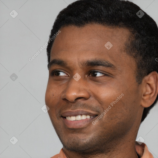 Joyful black young-adult male with short  black hair and brown eyes