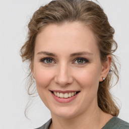 Joyful white young-adult female with medium  brown hair and grey eyes